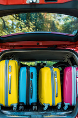 colored wheeled bags in car trunk