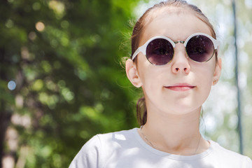 portrait of cute smiling girl in the forest in sunglasses close up