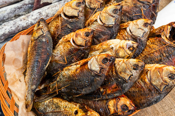 cooked hot smoked fish in a wicker basket on a table