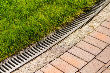 Rainwater gutters for rain along the lawn