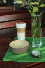 Still life - a bowl, cafe latte, a vase with a branch and a candle