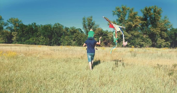 Happy family, mom, dad and son are walking in nature, launching an air snake. Stock footage.