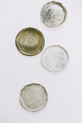 Hand made plates on white background. Flat lay, top view minimal pottery concept.