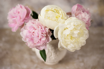Fresh pink peonies flowers on aged wooden background. Front view with copy space. Vintage Toned image.