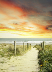Beach path leading to sea and bright sunrise