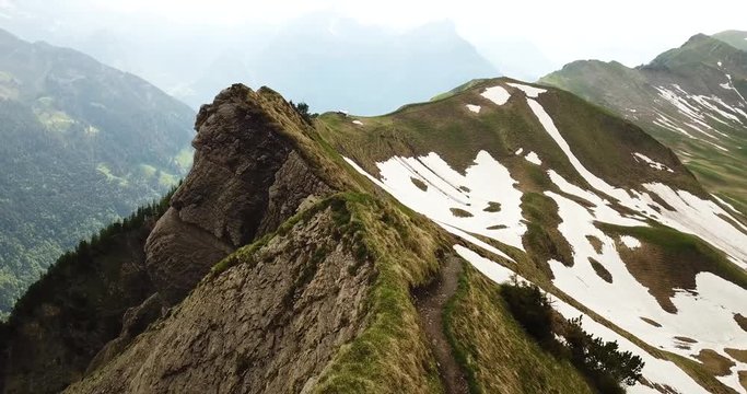Drone footage of a trail along a steep mountain ridge in the Swiss Alps.