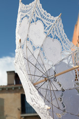 White parasol for sale by a Venice merchant.
