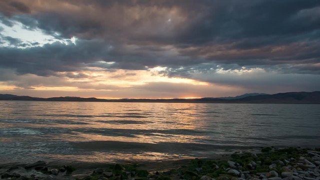 Colorful sunset time lapse over Utah Lake  as the sky lights up and reflects in the water on a hot summer day.