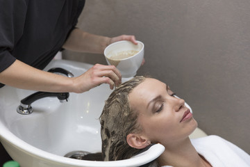 Hair beauty care, moisturizer application, hairdresser, hair mask of a beautiful girl, natural, health and beauty, closeup in beauty salon