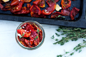 Sun dried tomatoes with herbs and sea salt in olive oil in a glass jar