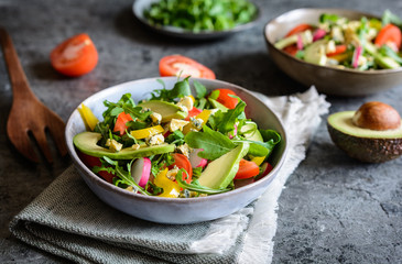Healthy arugula salad with avocado, radish, bell pepper, tomato and Roquefort cheese