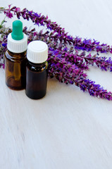 herb sage oil bottle on wood background 