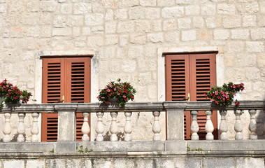 Fototapeta na wymiar Windows, Shutters and Flowers on Historic Home in the Old Town of Korcula, Korcula island, Croatia
