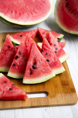Many slices of ripe juicy watermelon on bamboo board, closeup. Side view. Selective focus.