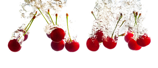 Red cherries dropped into the water with splash on a white background