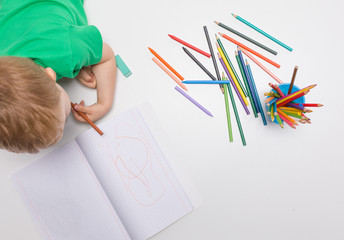 Little kid drawing with colour pencils