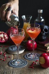 pouring a Poisoned Apple cocktail through a strainer