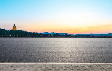 Asphalt road and hills silhouette at sunset in hangzhou