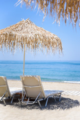 Sunbeds and umbrellas on tropical beach resort