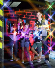 Fototapeta na wymiar Kids and adults in beams on lasertag arena