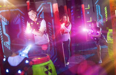 Parents and children playing laser tag in beams