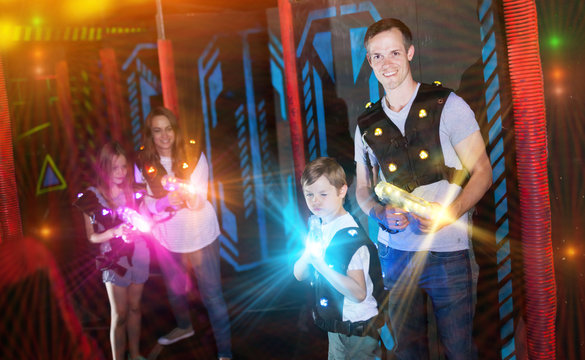 Father with son on lasertag arena in beams