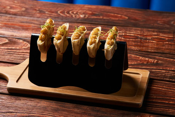 Delicious Labne and karri snack food with fried yellow peas, curry, lemon peel, in bread cake pita. vegetarian food on silver stand at luxury restaurant table, top view