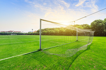 Green football field under blue sky background
