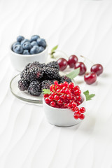 Fresh berries on a white textured table..