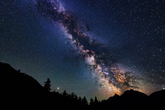 Astrophotography of Milky Way galaxy. Silhouette of mountains. Stars, nebula and stardust at night sky landscape