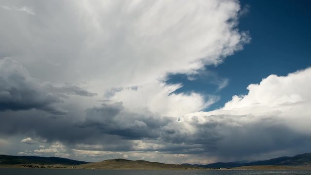 Timelapse of clouds over lake in wide open valley at Strawberry Reservoir, Utah.
