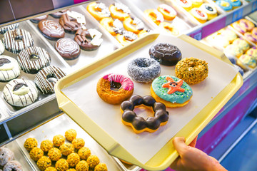 Customer choosing donuts from shelves