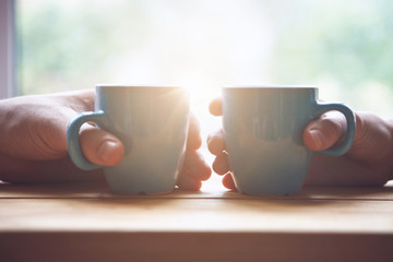 couple with two cups of morning coffee on sunrise light - 212680007
