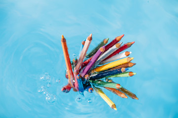 colored pencil floating in pool water