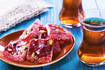 Traditional Turkish tea with traditional oriental sweet on blue wooden  surface.Turkish...