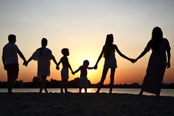 Naklejka na ściany i meble Silhouette of family on sunset background
