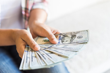 woman hands holding us dollar bills.
