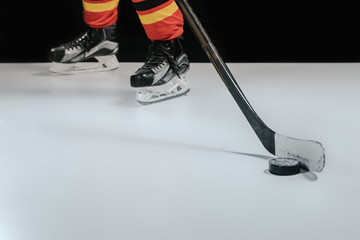 partial view of professional sportsman playing hockey on black