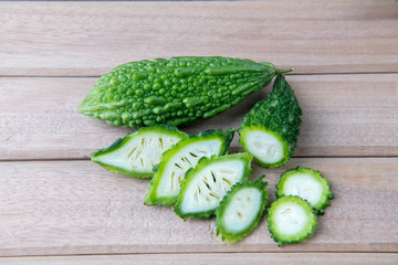 Closeup view of bitter gourd over wooden board background.