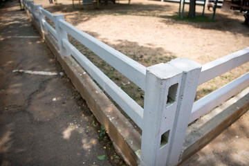 A view of a long white wooden fence.