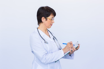 Portrait Of Female Doctor Writing On Clipboard Over a white background