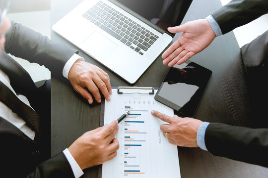 Close-up of business partners looking at business document chart