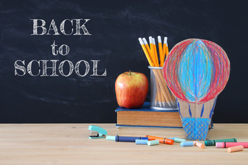 Back to school concept. hot air ballon and pencils in front of classroom blackboard.