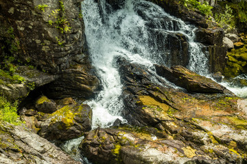 beautiful waterfall running through rock faces under the sun