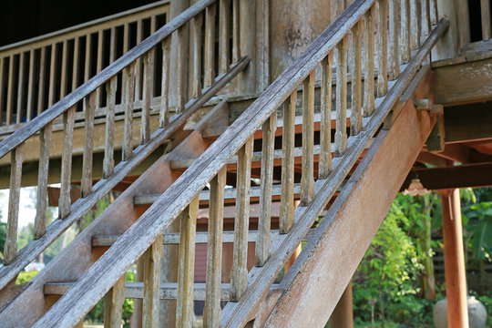 Old rustic wooden staircase in a local Thai village.