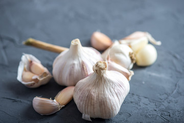 Group of garlic cloves scattered on a dark background. Important ingredient in cuisines of the world. Healthy product.