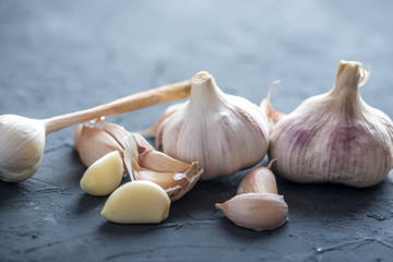 Group of garlic cloves scattered on a dark background. Important ingredient in cuisines of the world. Healthy product.