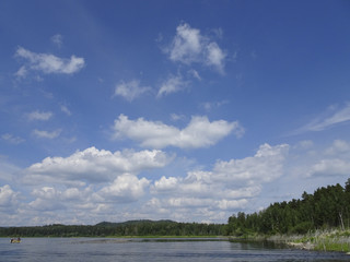 Summer landscape: blue sky and cirrus clouds over the lake on a sunny day