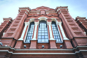 The facade of the cathedral is made of red brick with large windows. Holy Assumption Cathedral.