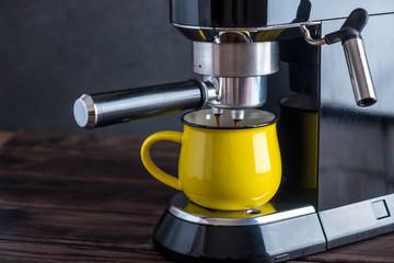 Preparation of espresso. Black coffee pouring from the machine in the Cup. Professional coffee brewing at home